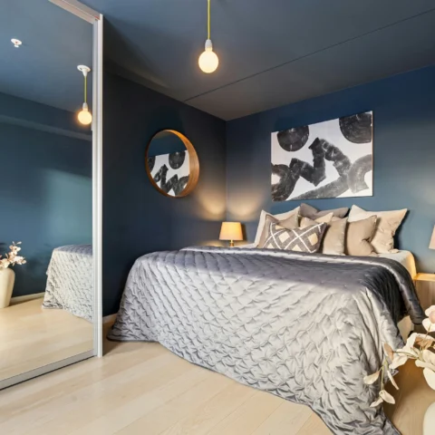 Dormitorio en azul profundo con espejo grande en el armario