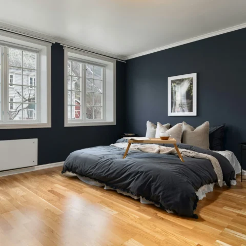 Dormitorio amplio y con buena iluminación con paredes pintadas de azul noche