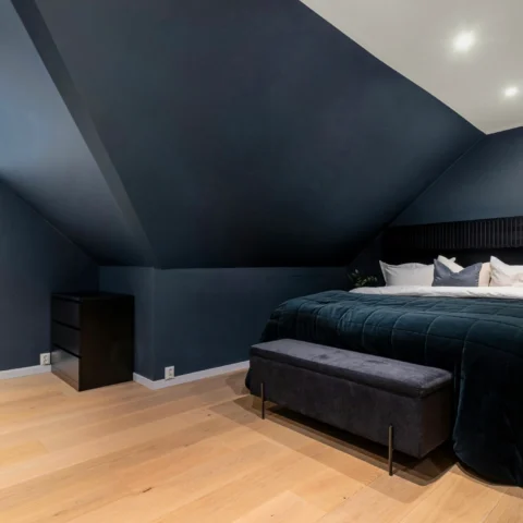 Dormitorio con paredes inclinadas de color azul