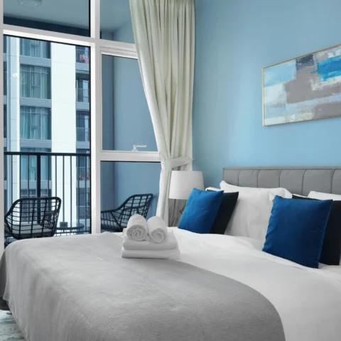 Dormitorio moderno y luminoso con paredes azul celeste y cama gris claro